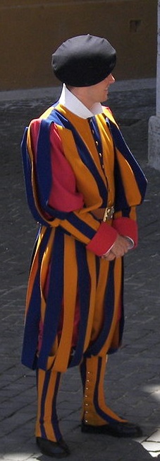 Photo Credit: https://commons.wikimedia.org/wiki/File:Swiss_Guard_near_Basilica_di_San_Pietro.jpg